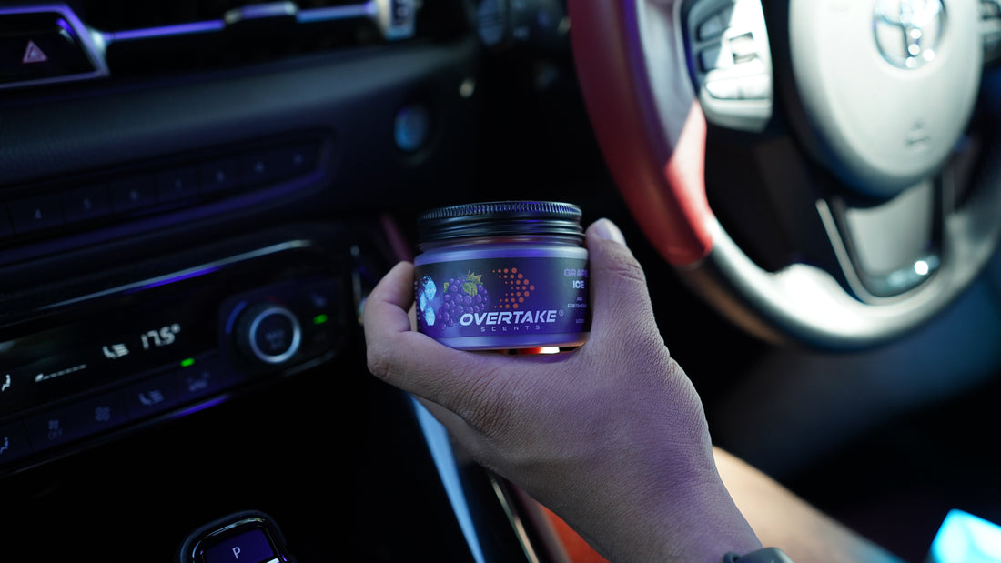 Driver holding Overtake Scent air freshener inside his Toyota