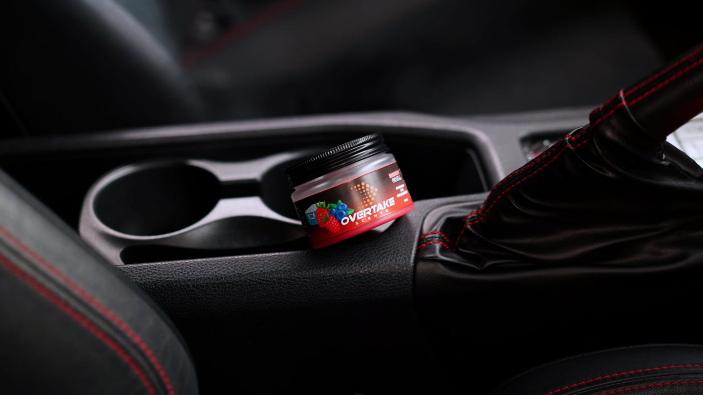 Berry Chill gel car air freshener in center console cup holder, black interior with red-stitched leather seats and manual gear gaiter — Overtake Scents