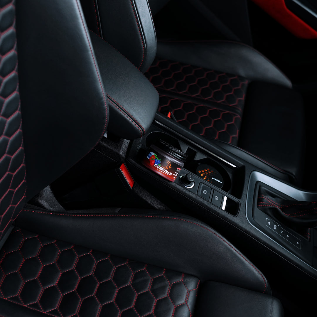 Berry Chill gel car air freshener in center console cup holder, black leather sport seats with red hexagonal stitching — Overtake Scents
