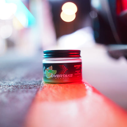 Citrus Lift gel car air freshener on road at night car meet with bokeh lights — Overtake Scents