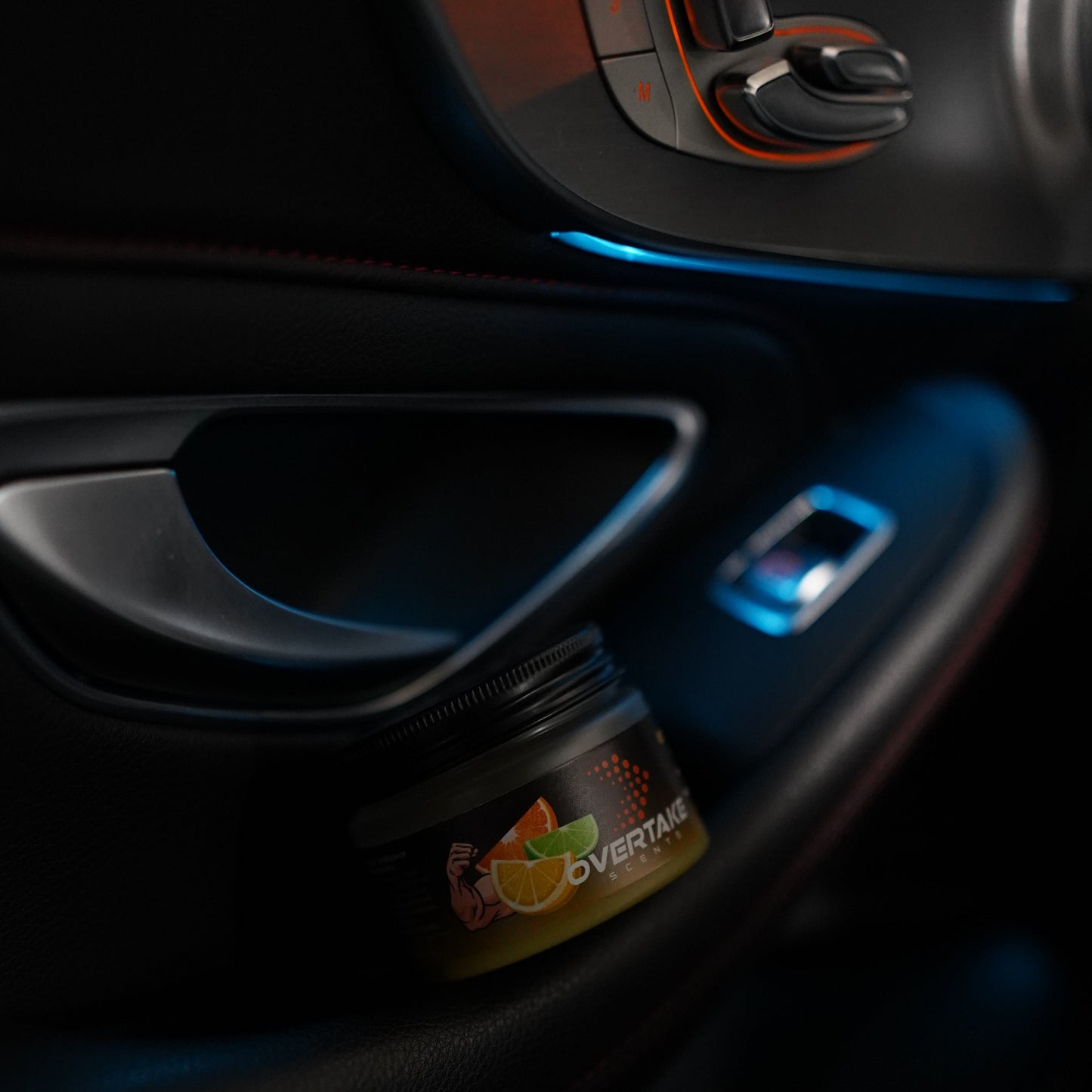 Citrus Lift gel car air freshener in car door storage pocket with blue ambient lighting — Overtake Scents