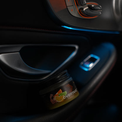 Citrus Lift gel car air freshener in car door storage pocket with blue ambient lighting — Overtake Scents