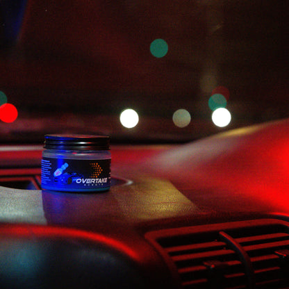 JDM Fizz gel car air freshener on car dashboard at night with city lights bokeh in background — Overtake Scents