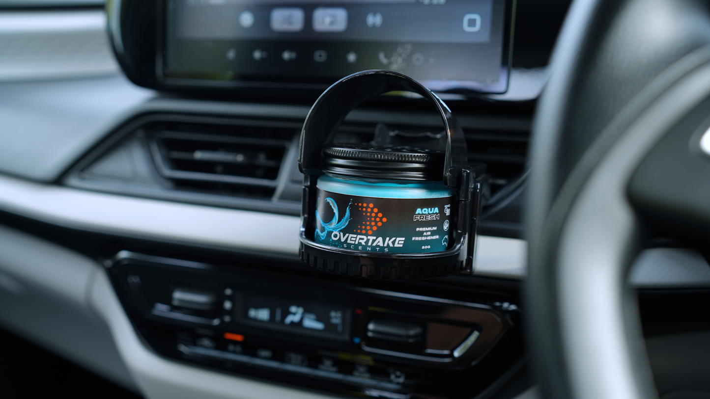 Overtake vent mount holding gel car air freshener in car vent, front sun visor open — Overtake Scents