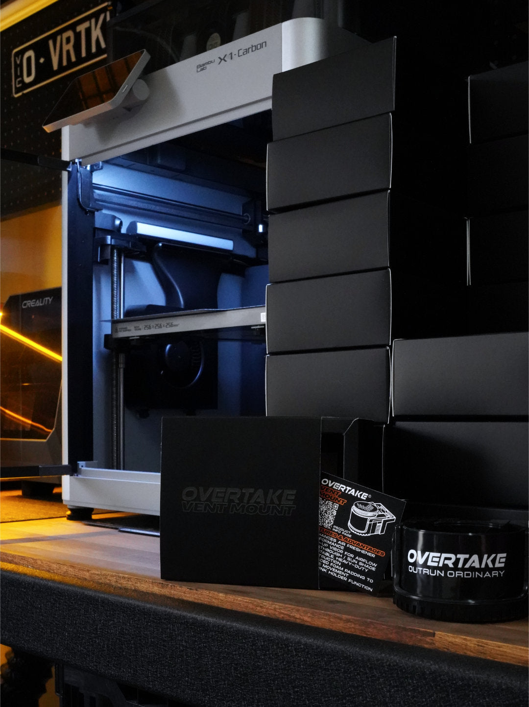 Overtake vent mount packaging and accessory displayed in front of Creality 3D printer in production workshop — Overtake Scents