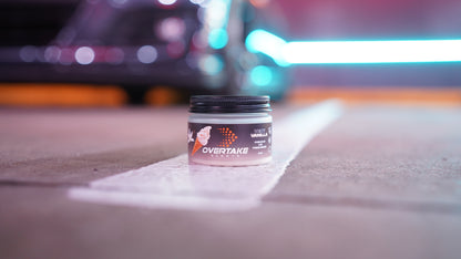 Very Vanilla gel car air freshener on road marking at night with neon city lights bokeh — Overtake Scents